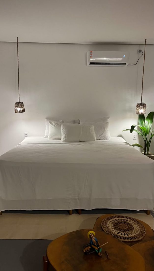 Cama de casal da Suíte Carnaúba, com ar-condicionado e luminárias