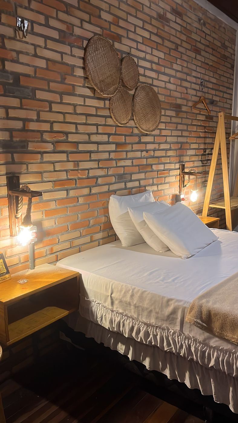 Cama de casal com travesseiros brancos, à noite